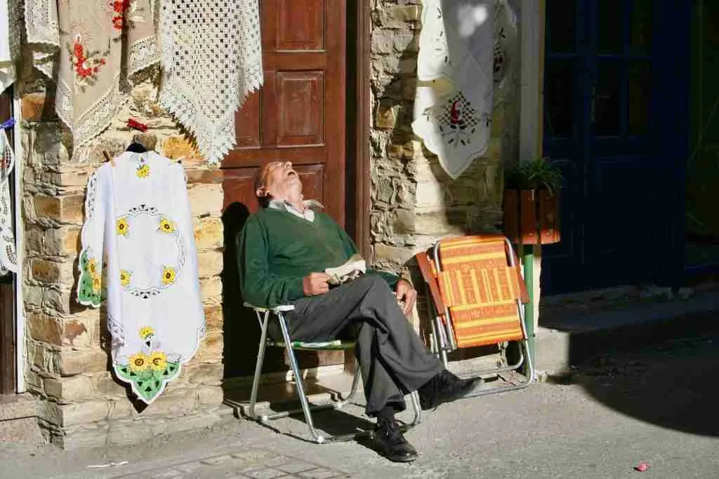 old man sleeping in a chair with his head back having the perfect power nap
