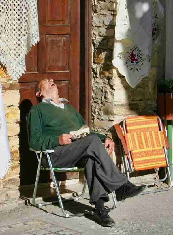 old man sleeping in a chair with his head back