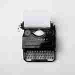 typewriter on a white background for writing assignment self-coaching resources