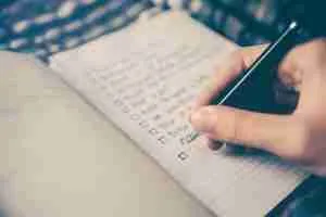hand writing self-coaching ideas in paper planner
