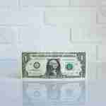 dollar bill in front of a wall