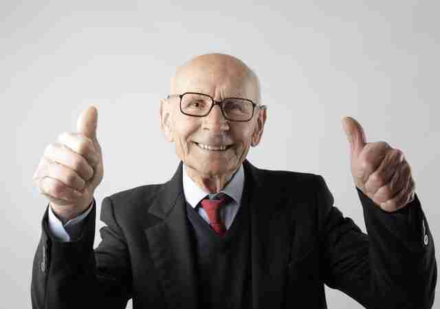 man in a suit giving the thumbs up sign