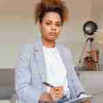 woman holding pen and clip board to take a personal assessment for self-coaching resources