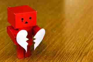 paper robot holding a broken heart because of marital problems