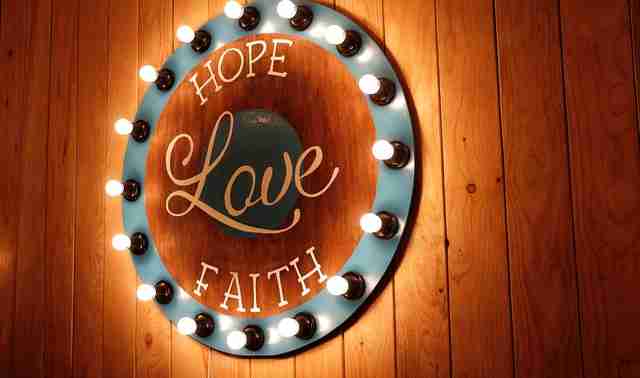 lighted plaque hanging on the wall with the core values, hope, love, and faith