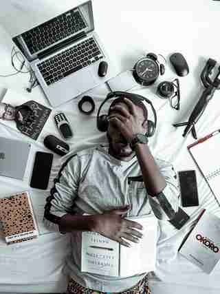 man surrounded by technology looking stressed from too much screen time