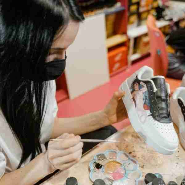 woman crafting for mental sharpness by painting tennis shoes