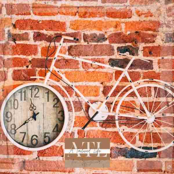 bicycle on a brick wall with front tire made from a clock symbolizing 8 steps to get more out of life